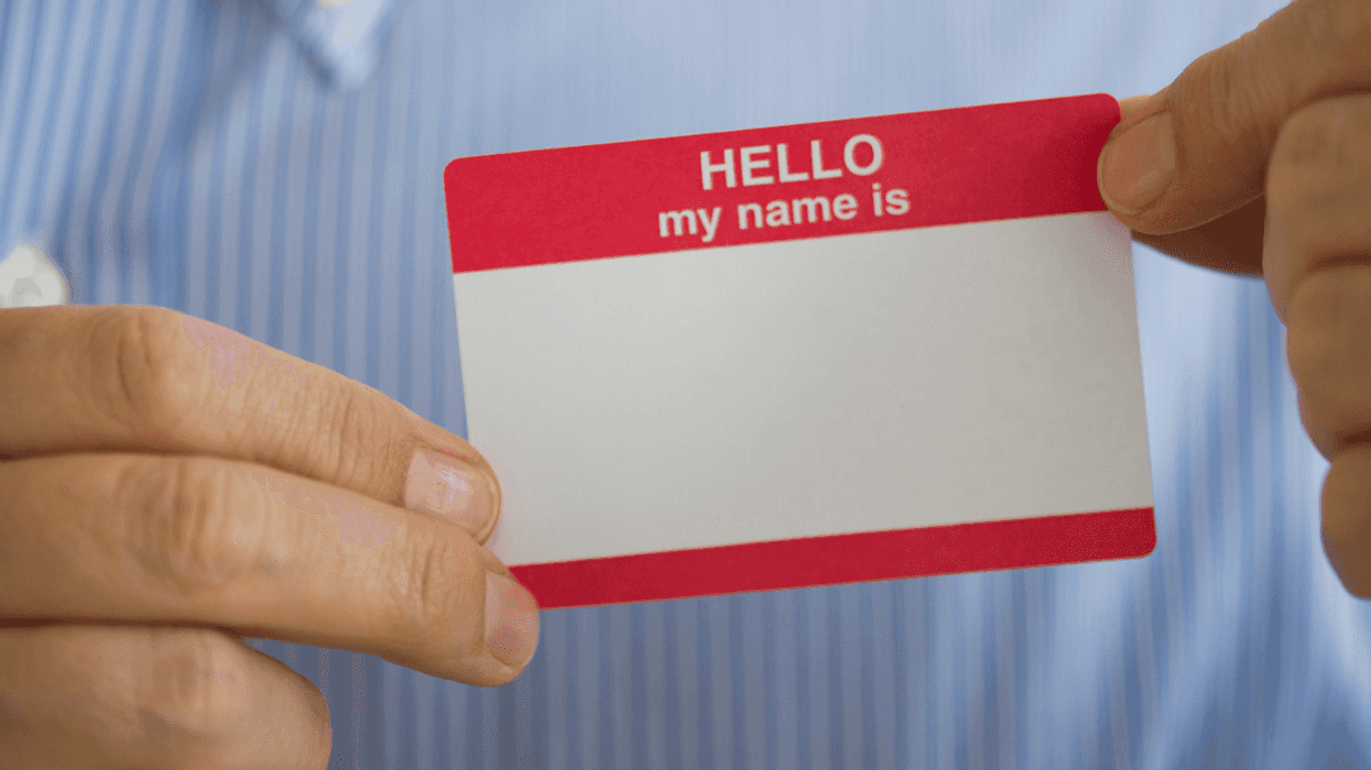 person holding blank adhesive name tag