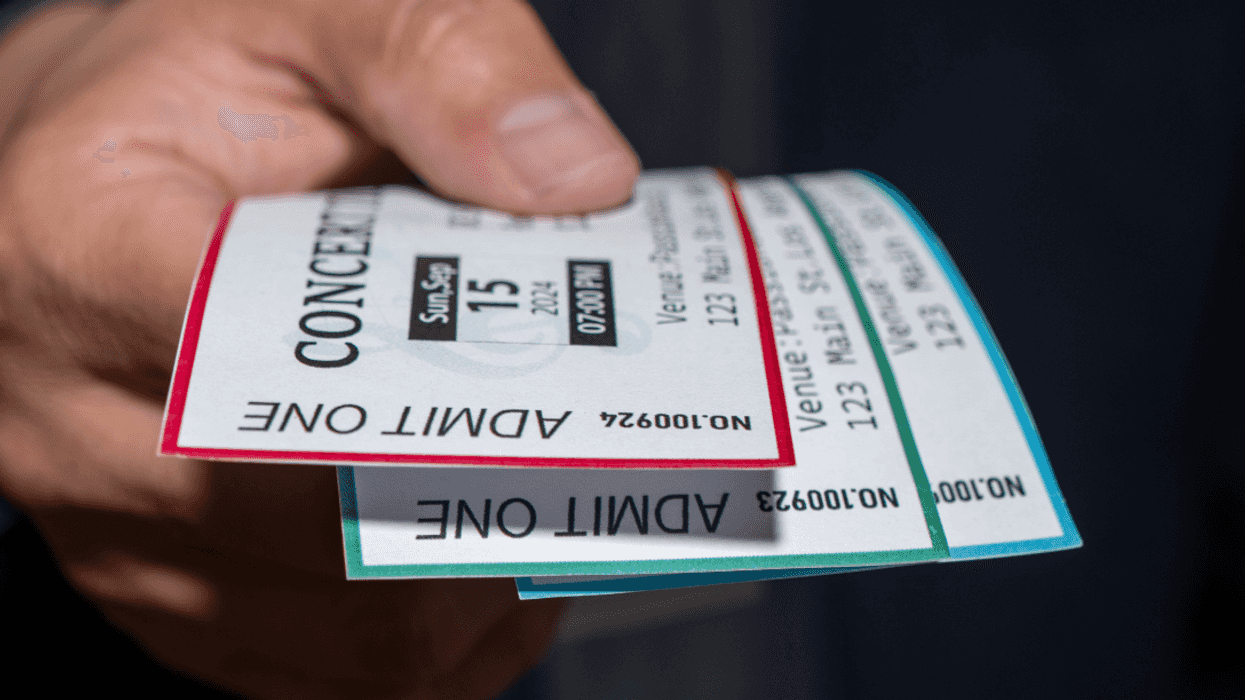 person holding concert tickets