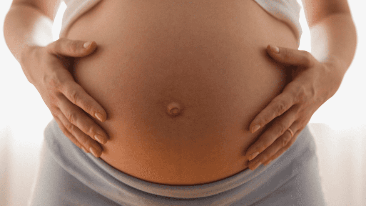 person holding their pregnant belly