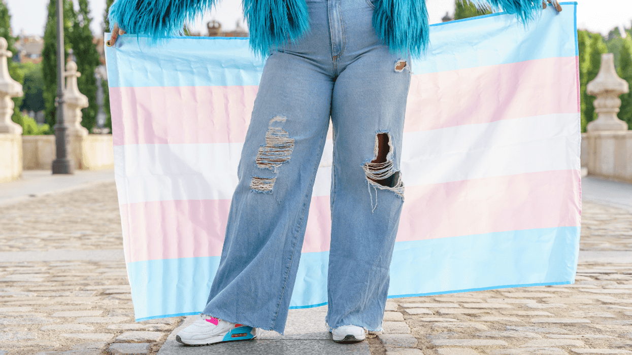 person holding trans pride flag