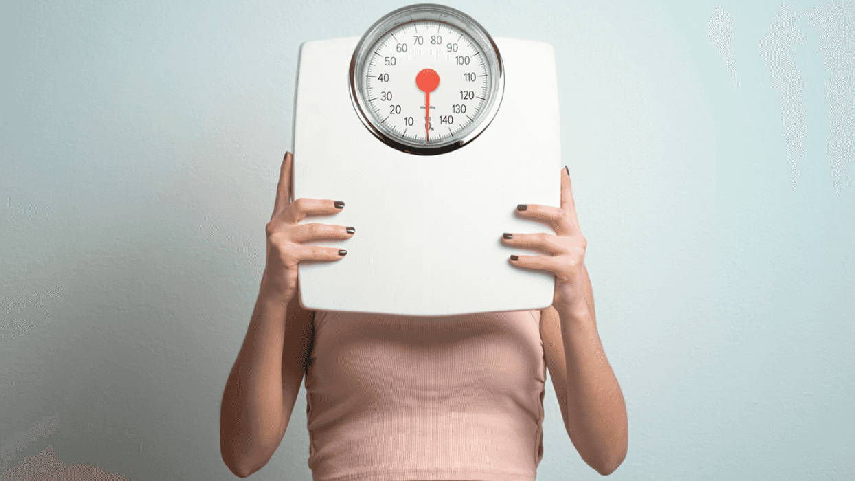 person holding up bathroom scale
