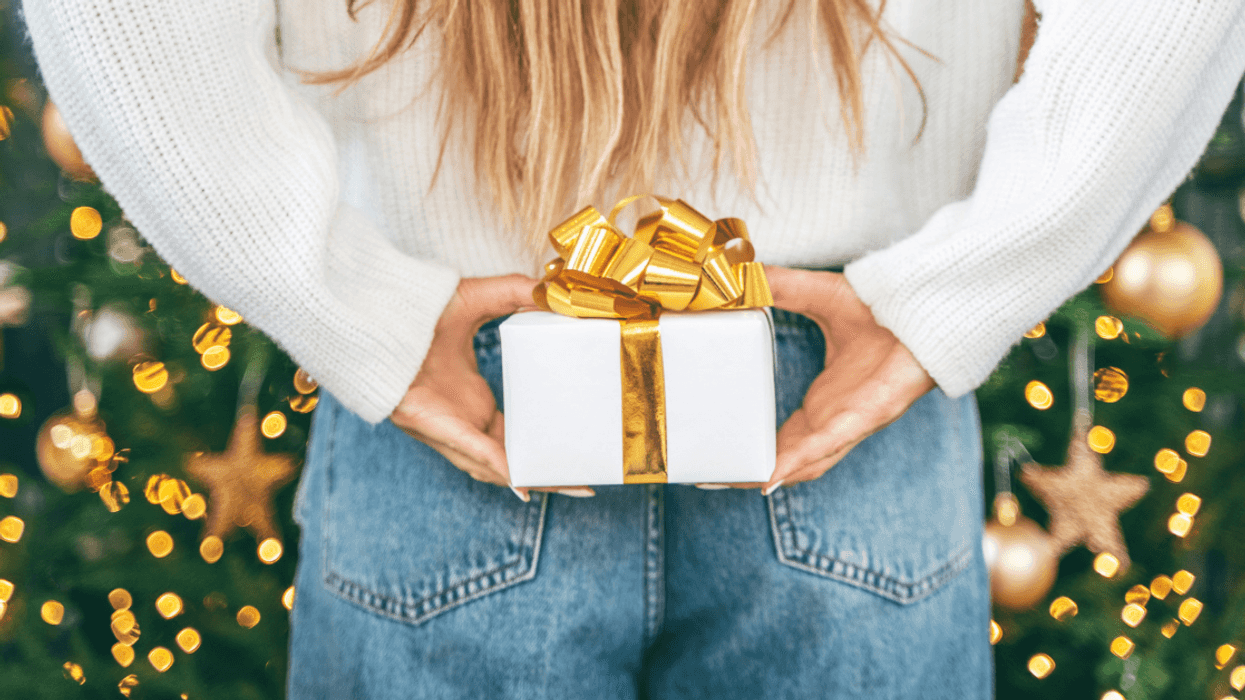 person holding wrapped gift behind their back