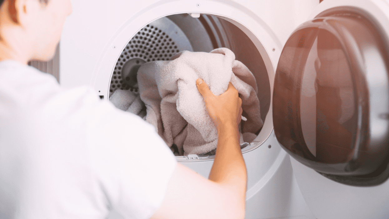 Person loading laundry into machine