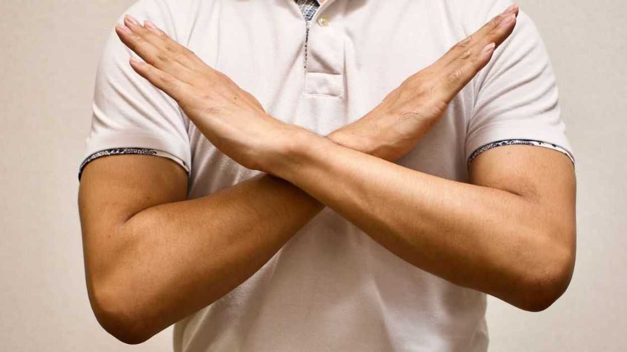 Person making X with their arms across chest