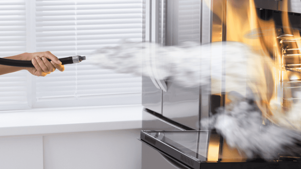 Person putting out fire in a stove