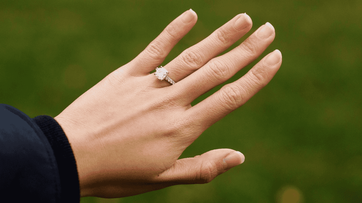 person showing off diamond engagement ring