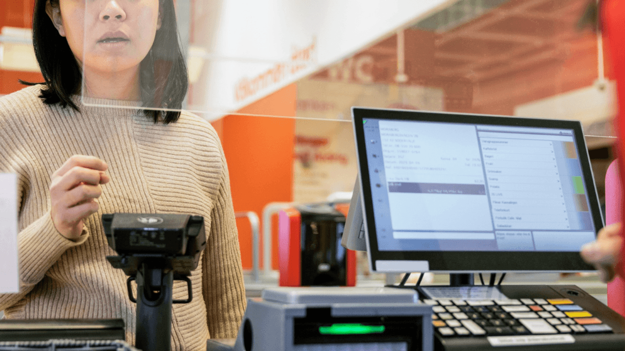 person standing in front of cash register