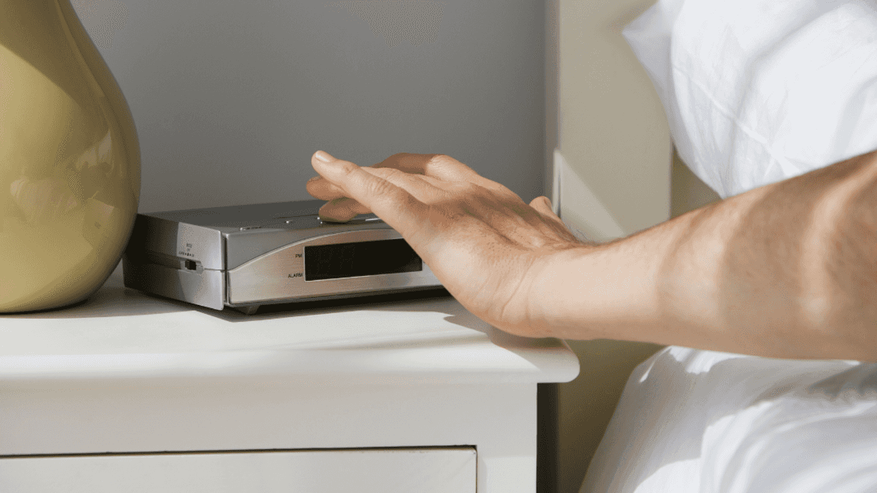 person turning off alarm clock