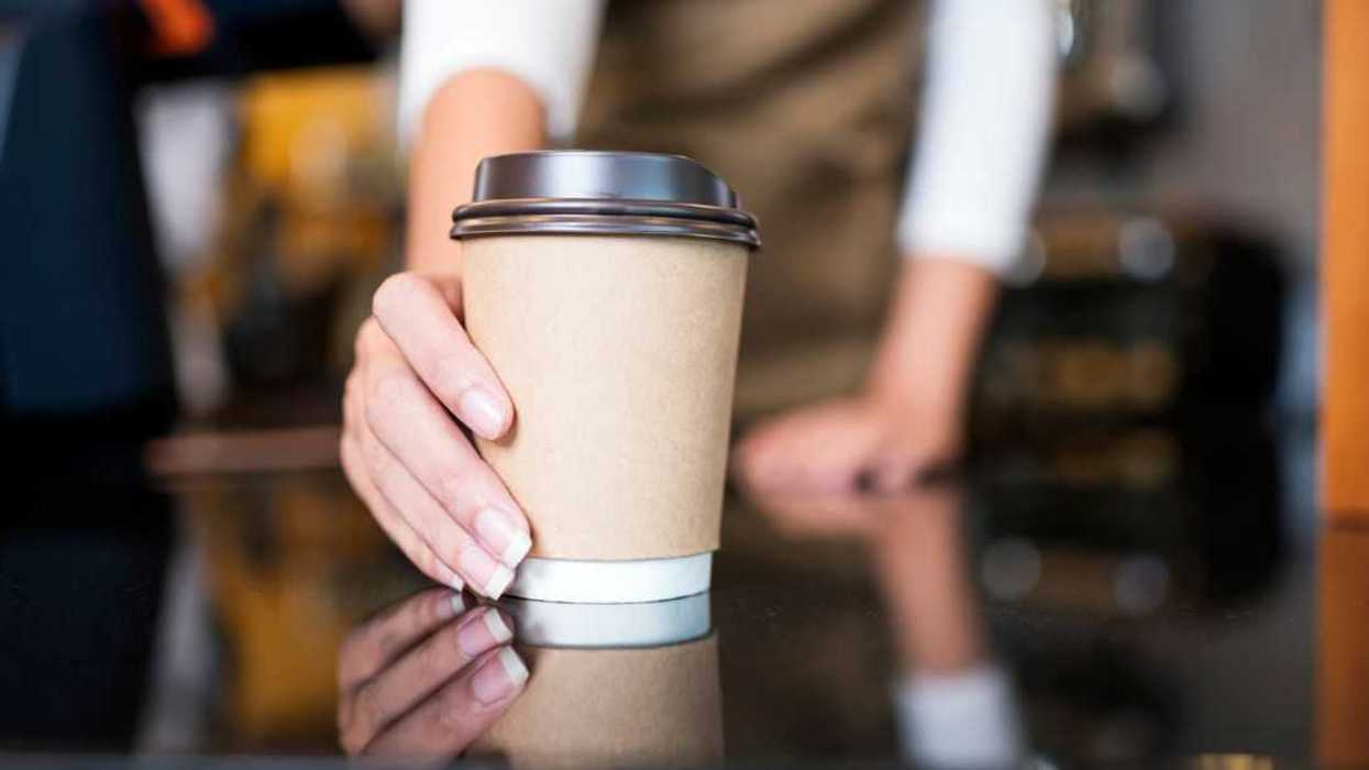 Please enjoy drinking a coffee. The unrecognizable waitress serving coffee to a customer in a cafe. Serving food and Drink, Point of Sale System.