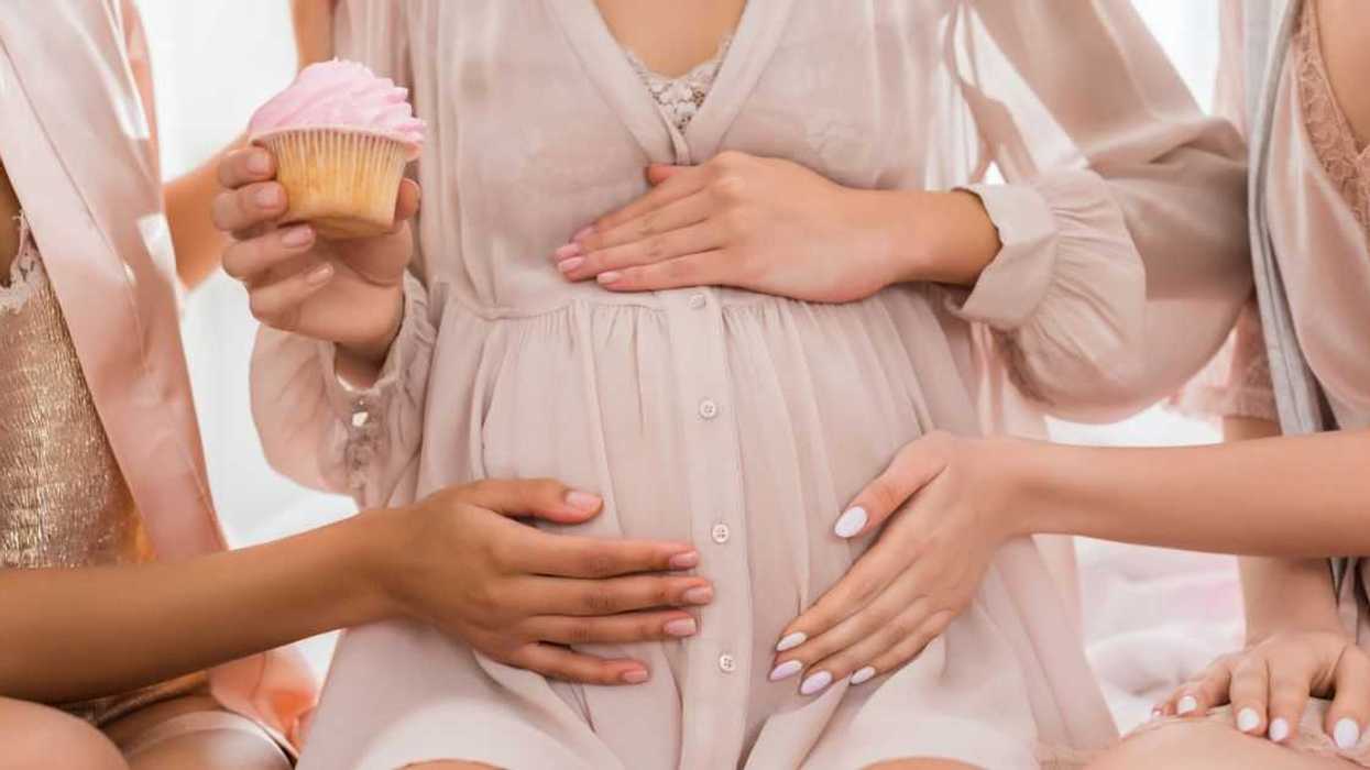 Pregnant woman holding cupcake