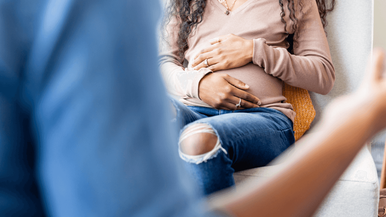 Pregnant woman with her hands on her stomach
