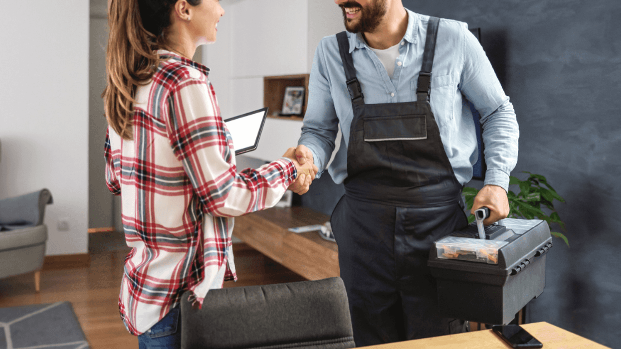 Repairman and female customer shaking hands