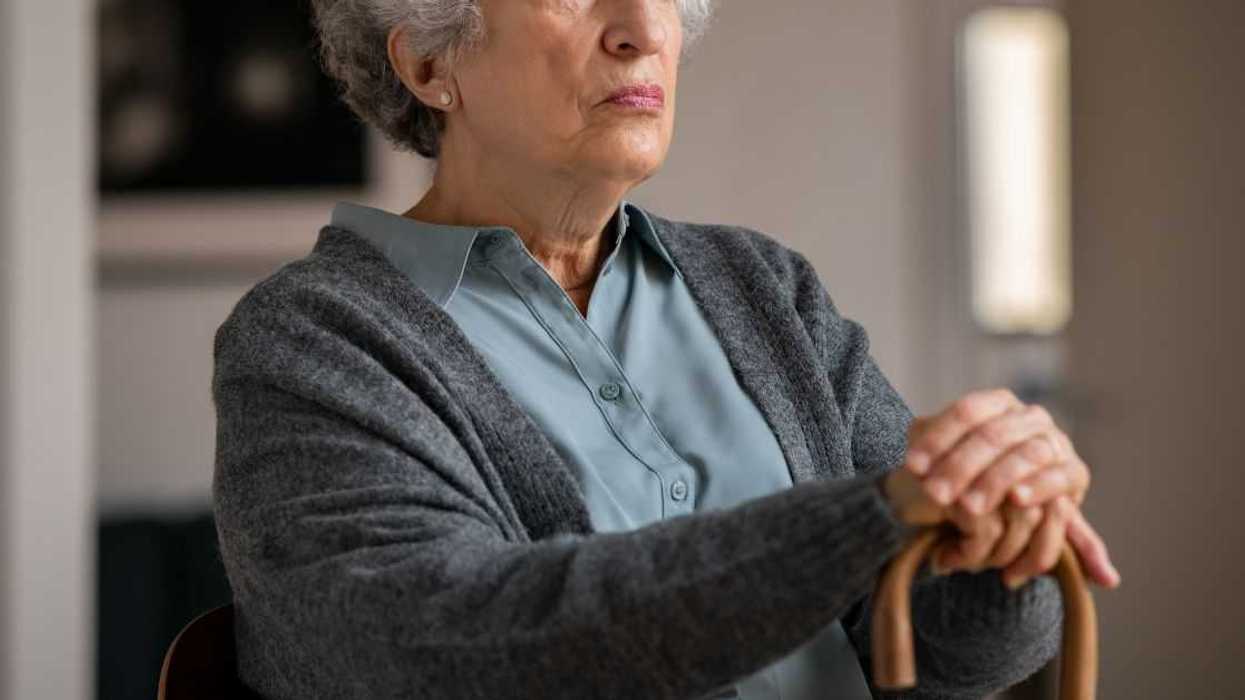 Retired unhappy woman with wooden walking cane