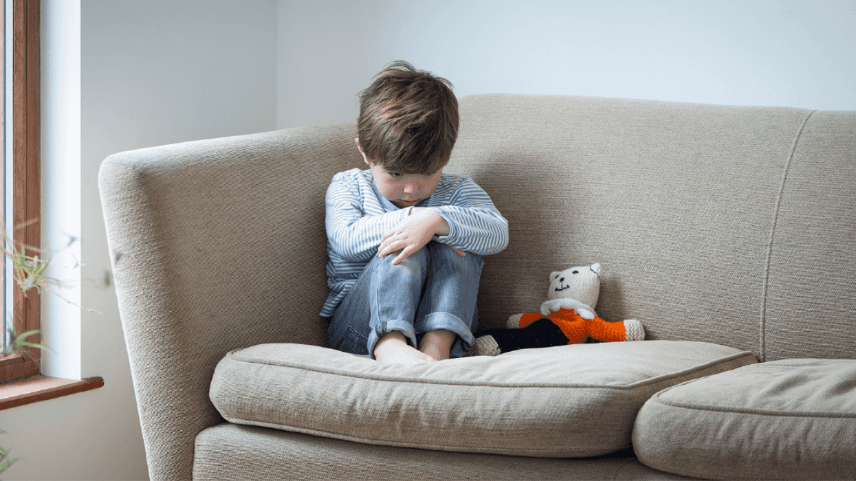 Sad boy sitting on couch