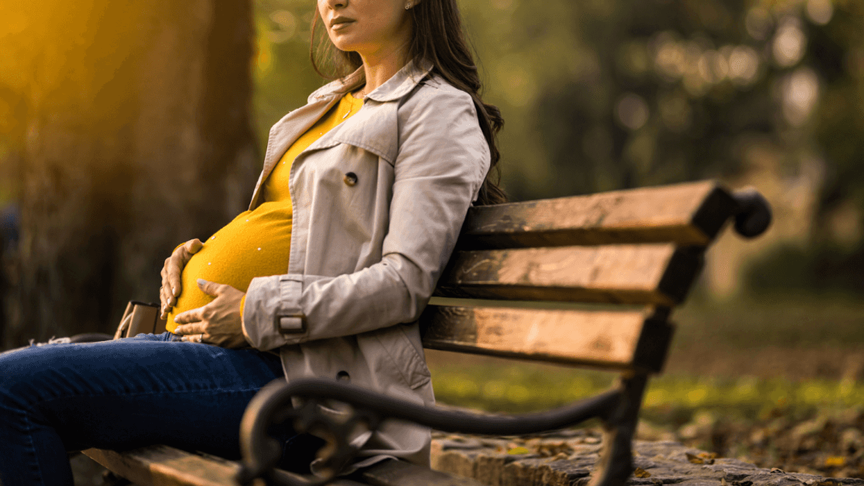 Sad pegnant woman on a bench.