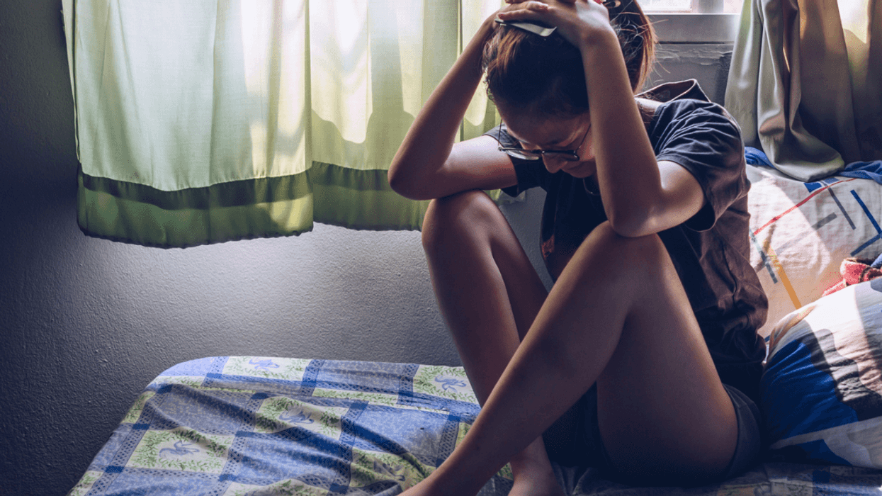 Sad teenage girl on her bed.