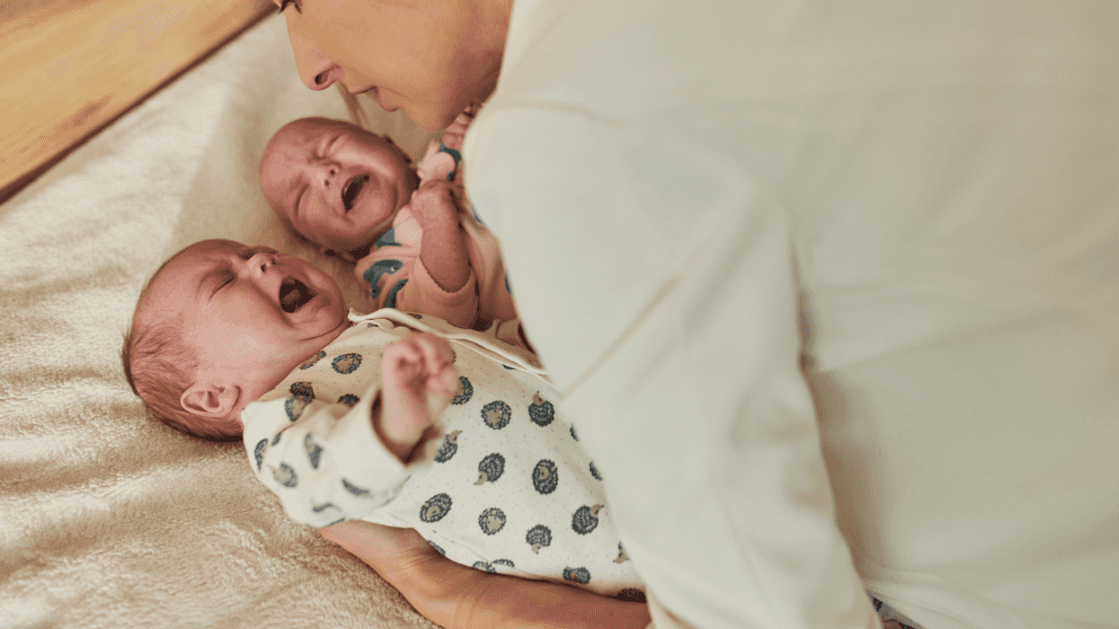 Saddened woman looking at twin baby boys