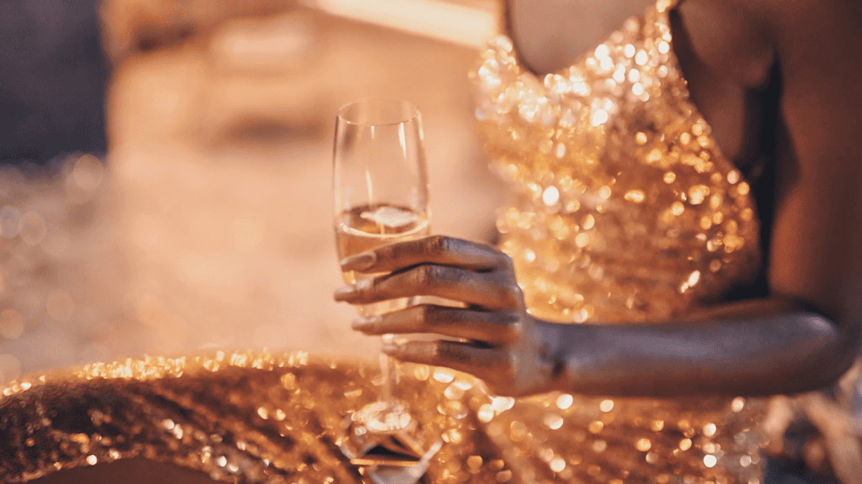 seated woman in gold dress with champagne