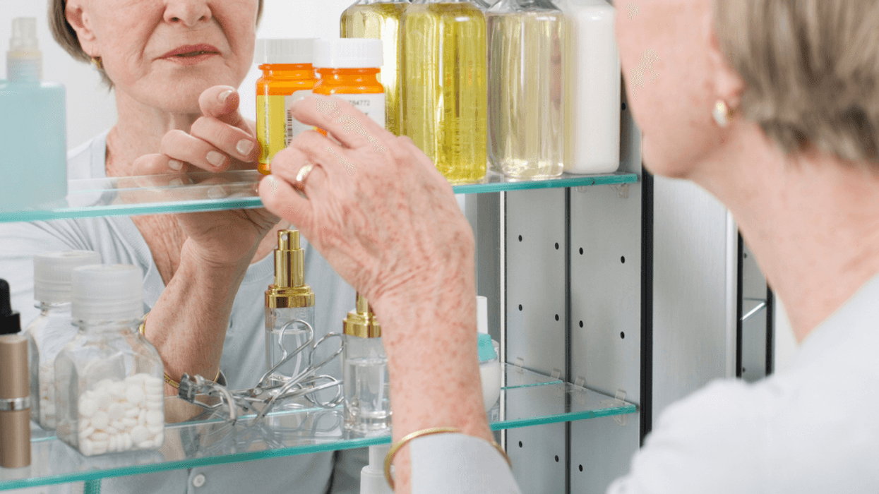 Senior woman looking in medicine cabinet