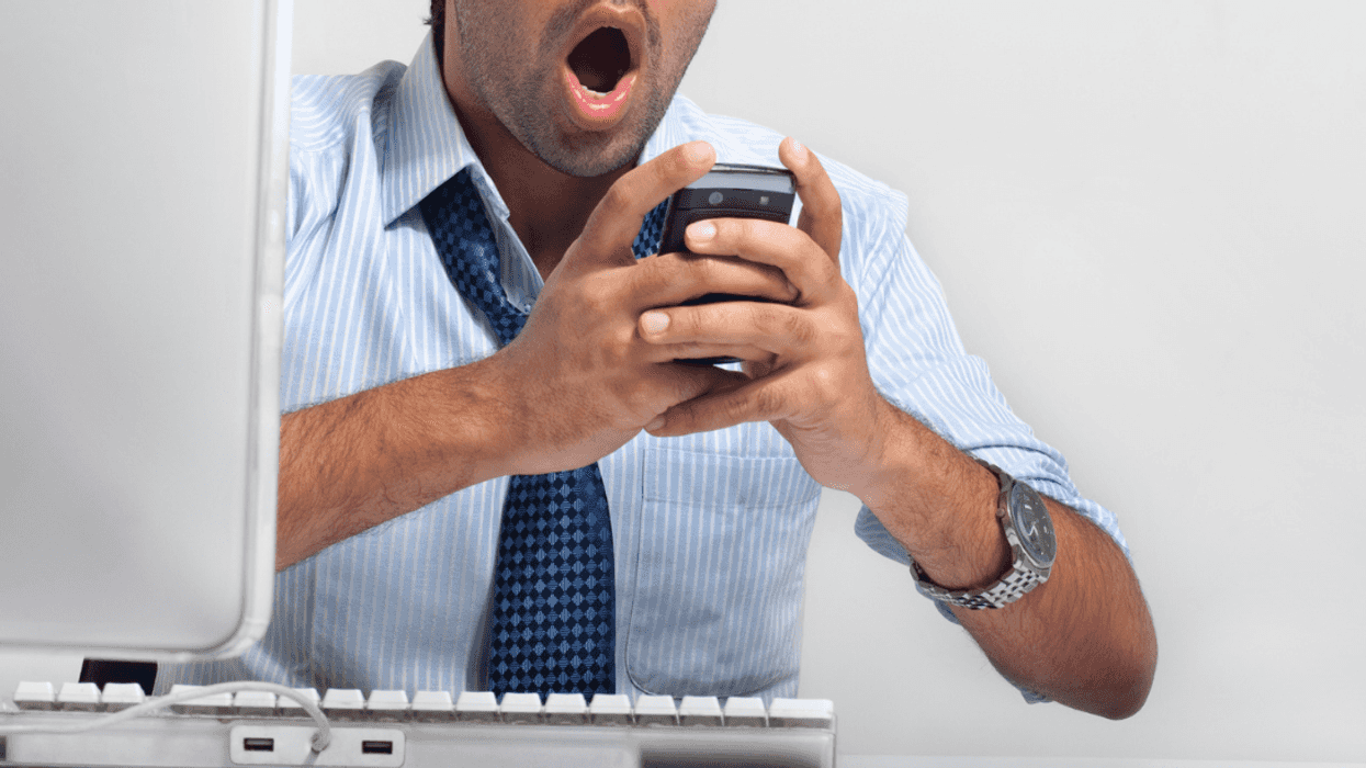 Shocked person looking at phone at work
