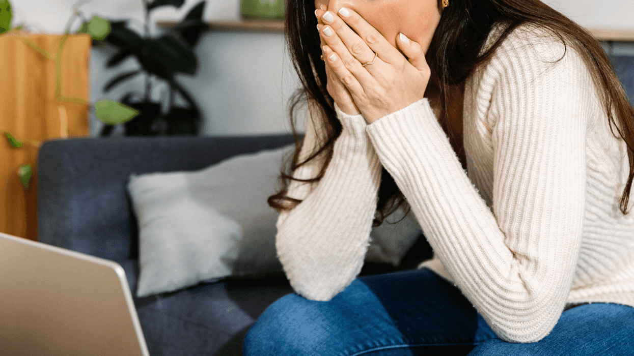shocked young woman looking at laptop