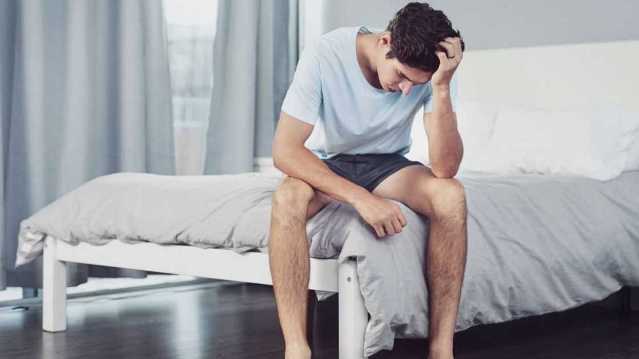 Shot of a young man looking depressed in his bedroom