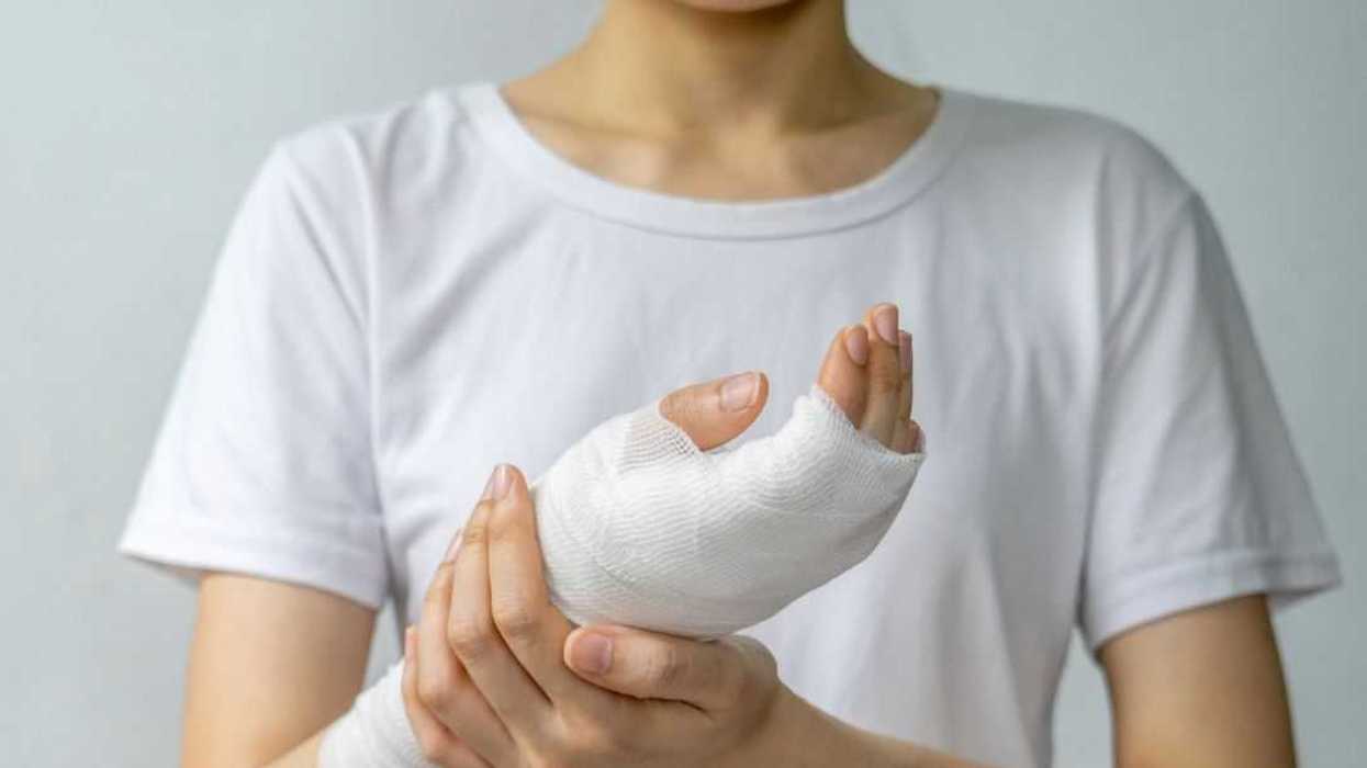 Shot of an unidentifiable woman holding her wrapped, wounded hand.