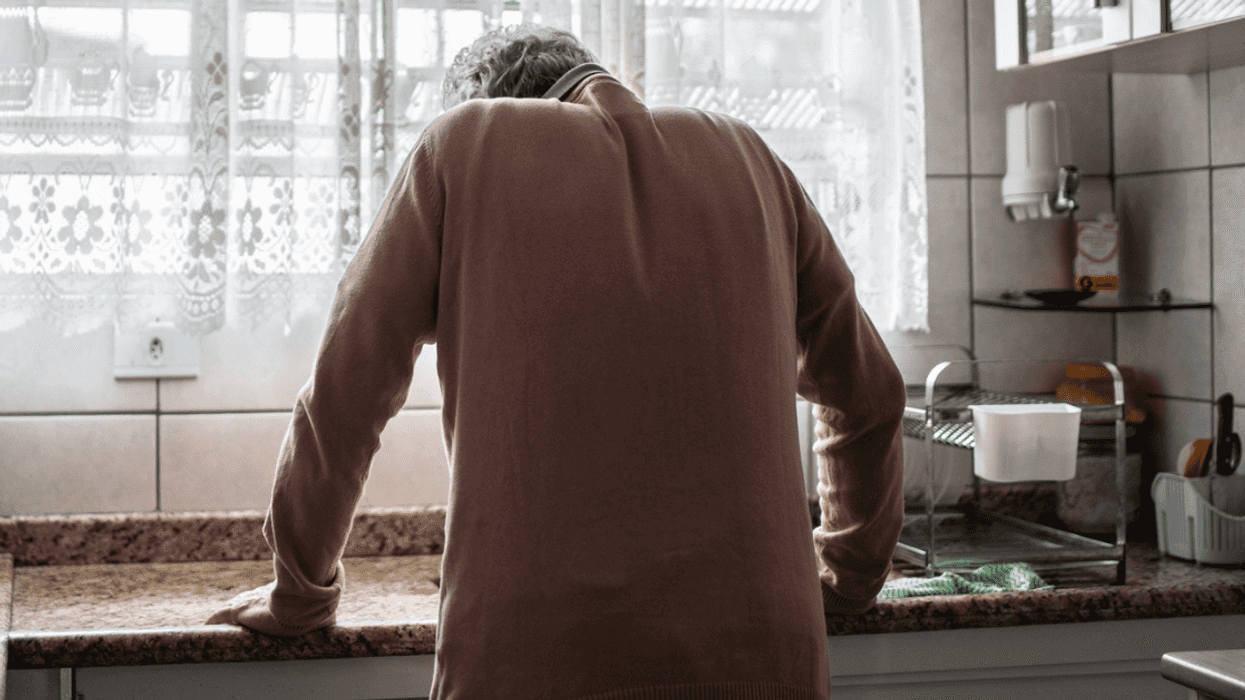 Sick man leaning over sink
