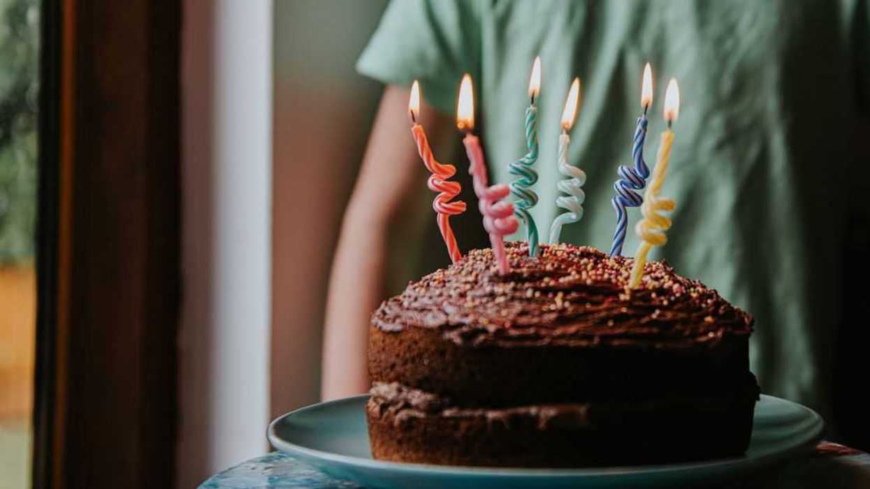 Six-year-old celebrating with lit birthday cake