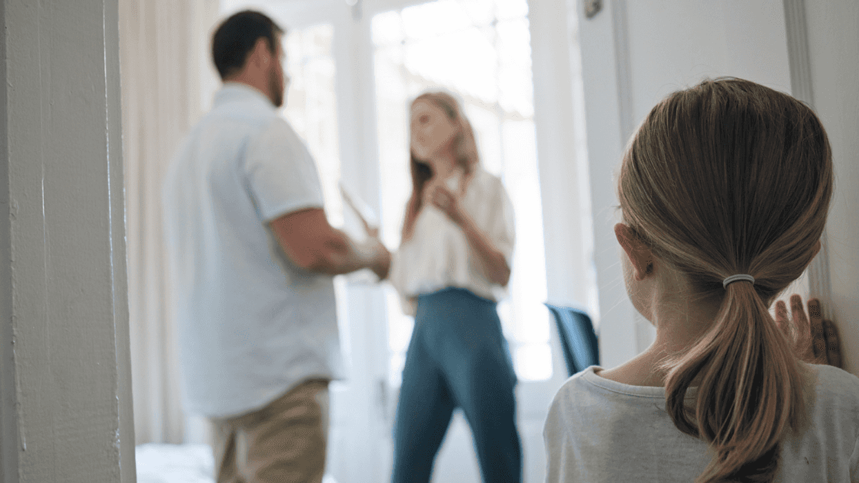 Small child looking in on parents arguing