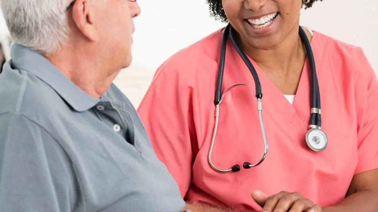 Smiling nurse comforts a patient.