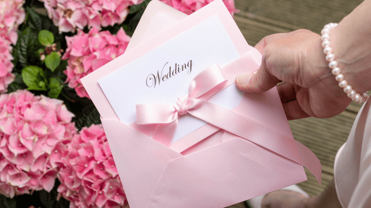 Someone holding wedding invitation