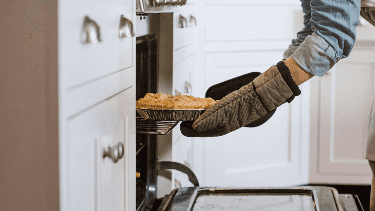 Someone pulling a pie out of the oven.