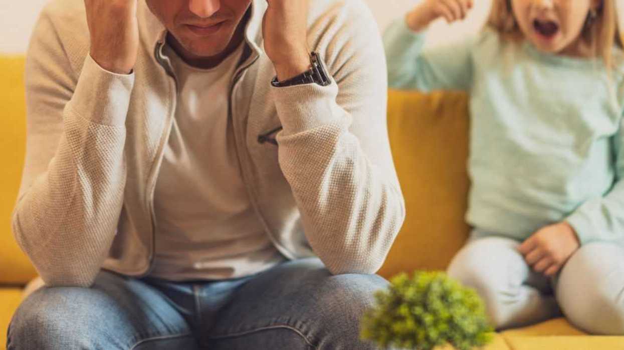 Stressed father is feeling desperate because of his screaming daughter.