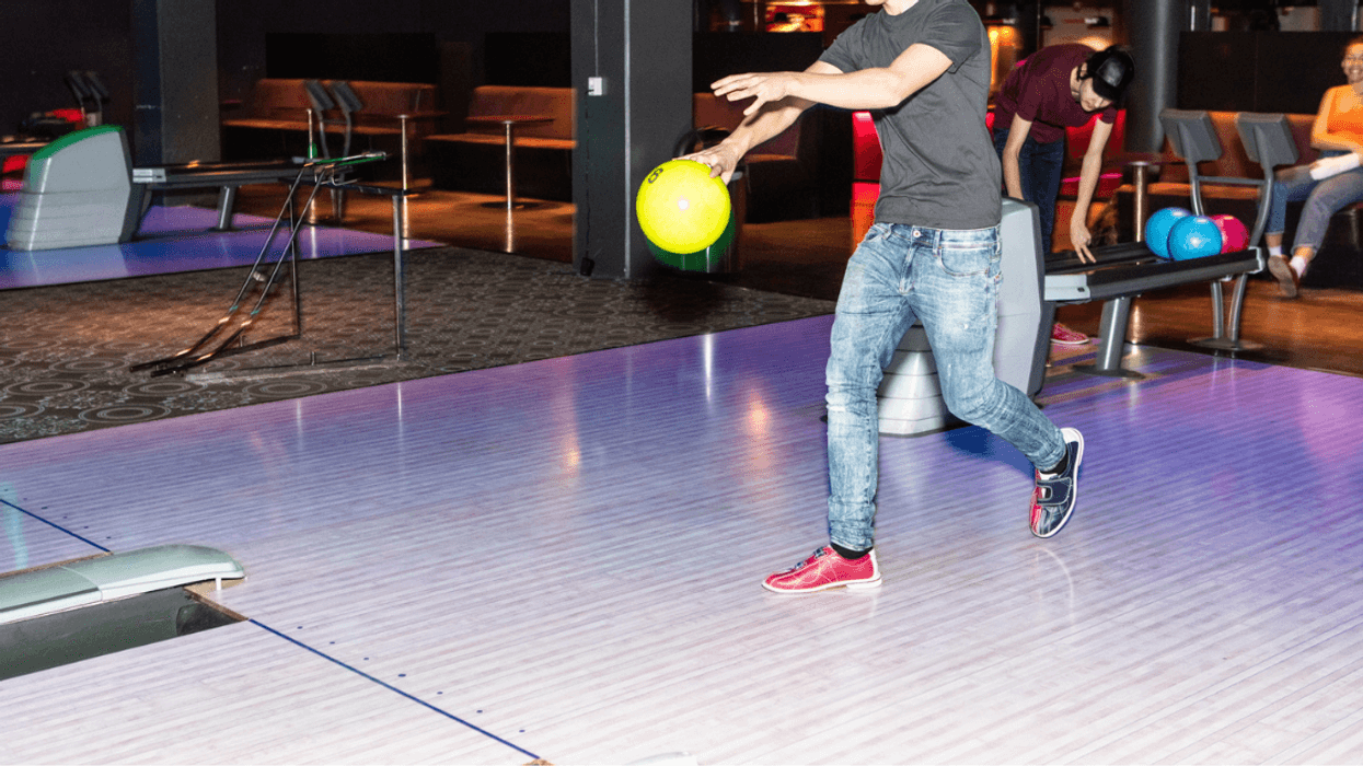 Teen boy bowling.