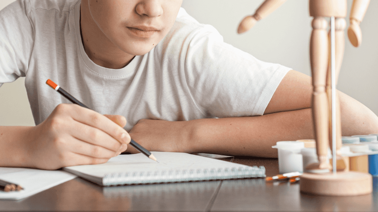 Teen drawing using wooden figure model