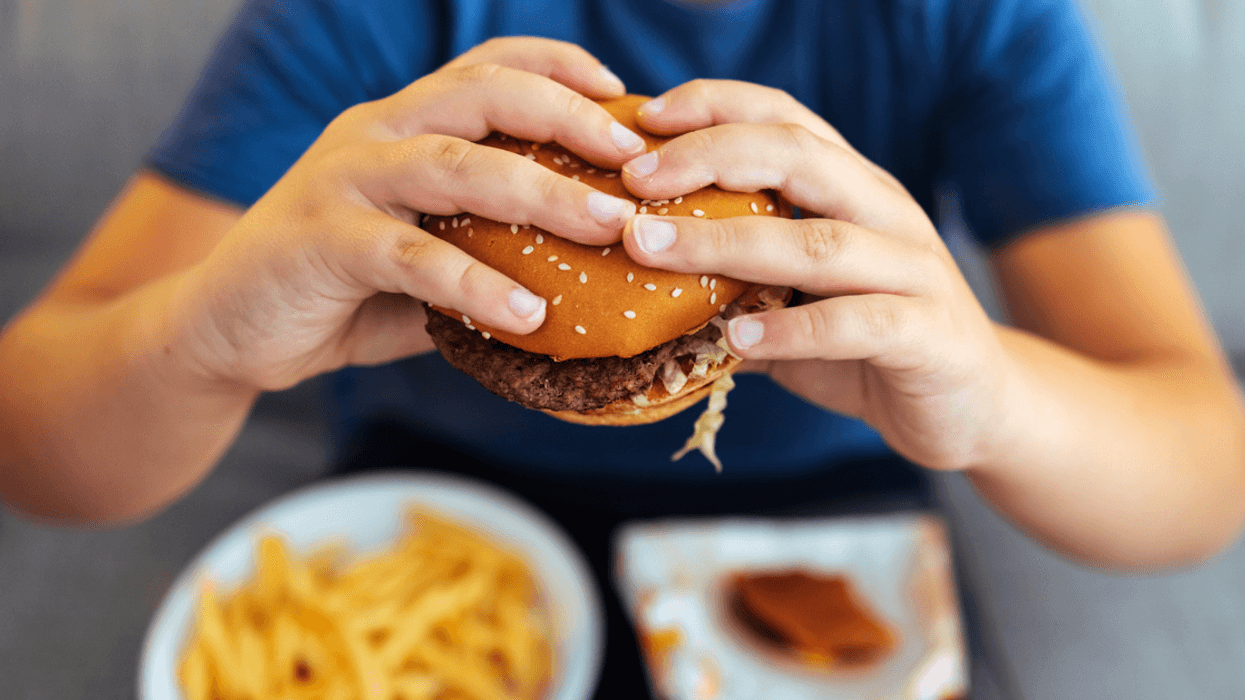 teen eating a hamburger meal