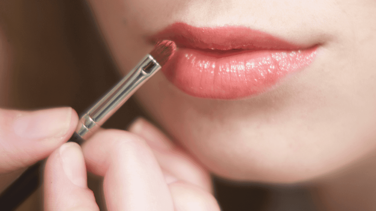 Teen girl applying lipstick