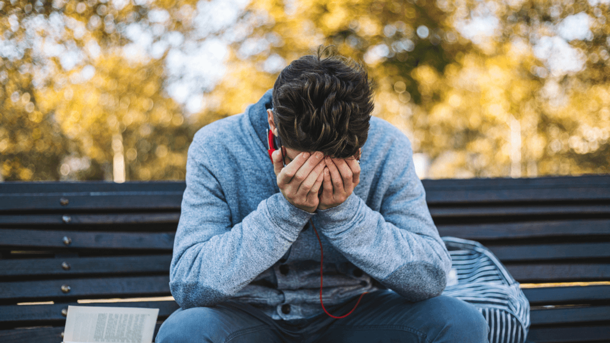 Teenage boy crying on bench