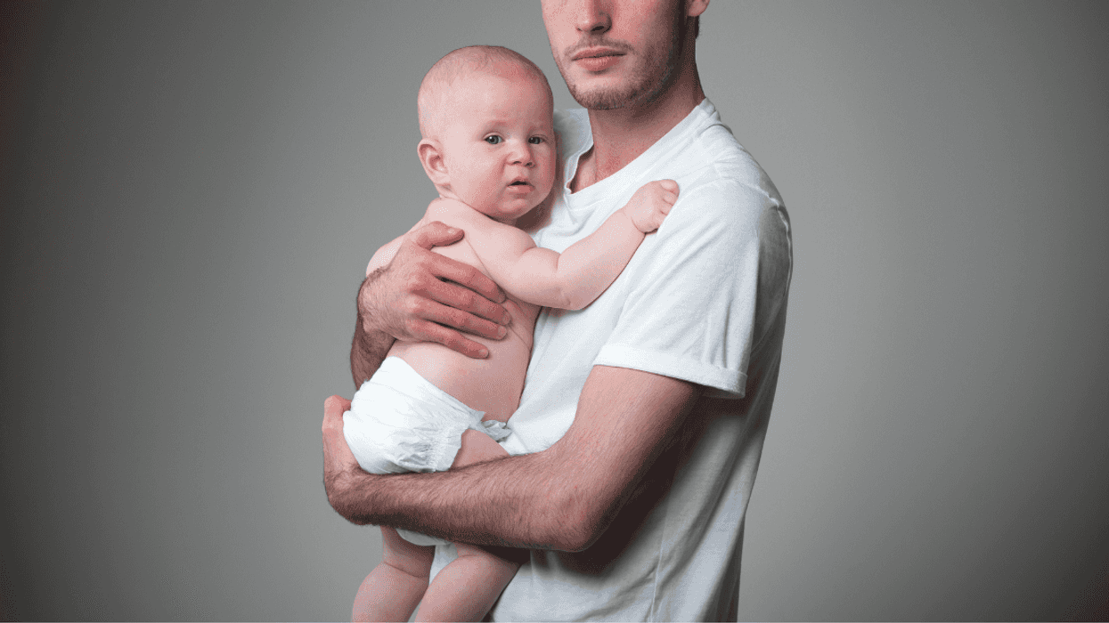 Teenage boy holding a baby