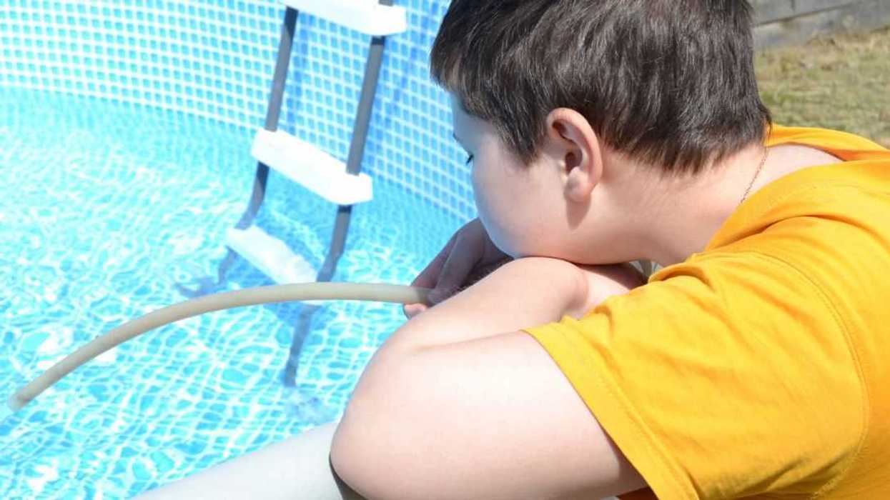 Teenage boy stares into a pool.