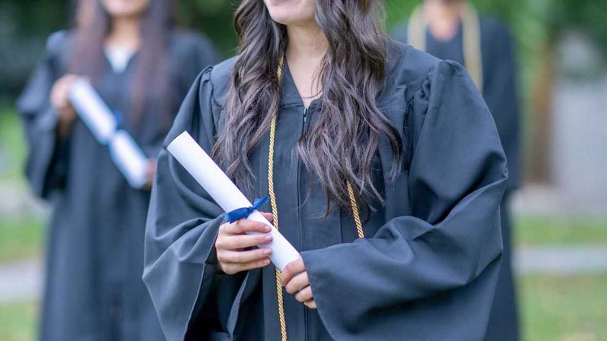 Teenage female graduate holding a diploma