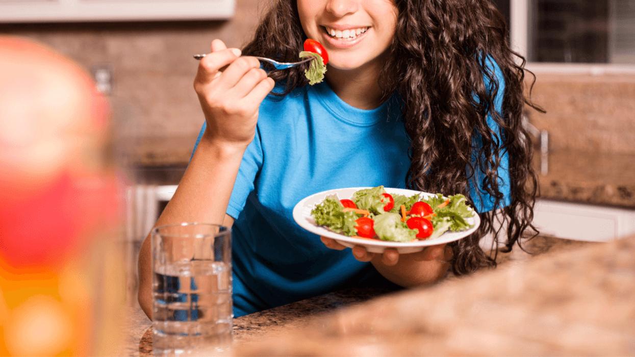 Teenage girl eating vegetables