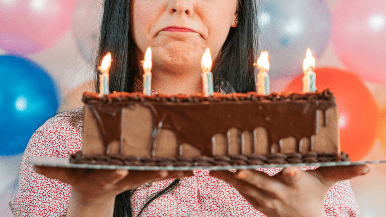 Teenage girl sad while looking at birthday cake
