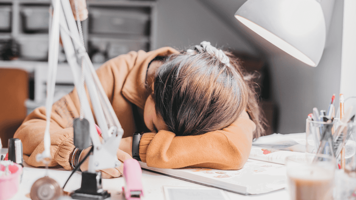 Teenage girl with her head on her desk.