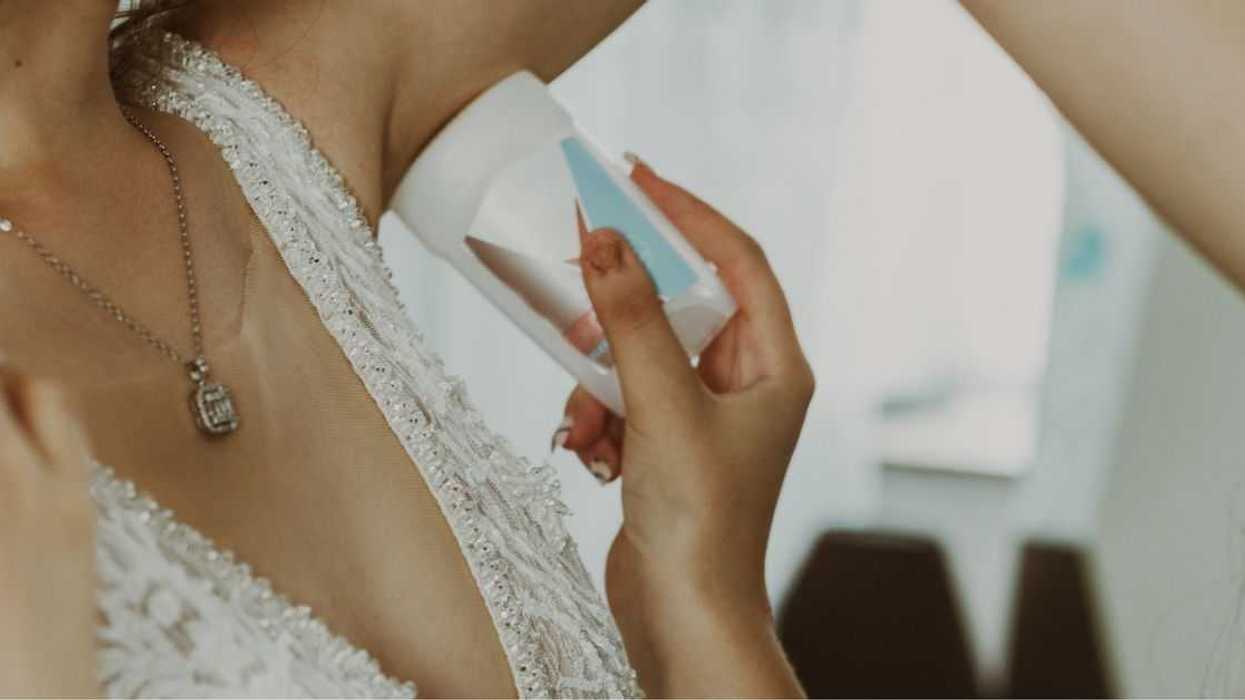 The Maid Of Honor Applies Antiperspirant To The Bride's Armpits.