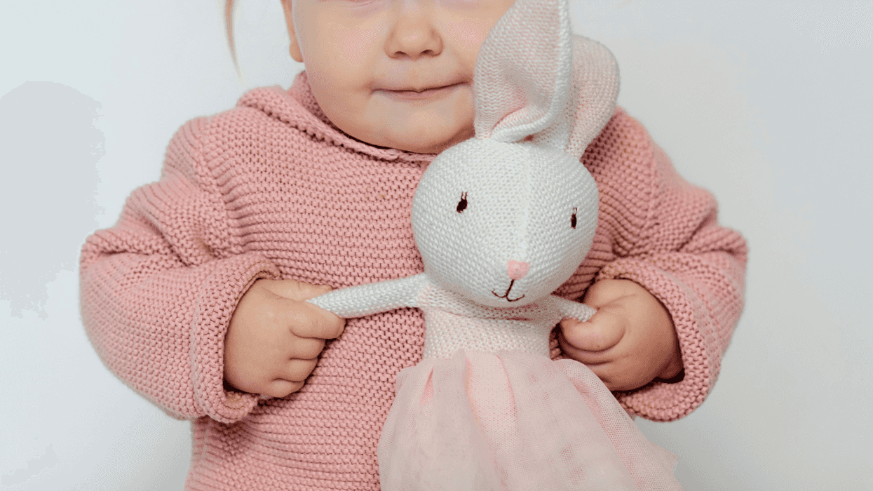 toddler playing with stuffed rabbit toy