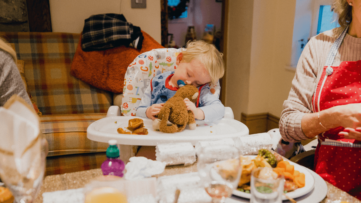 toddler sleeping in high chair at dinner table