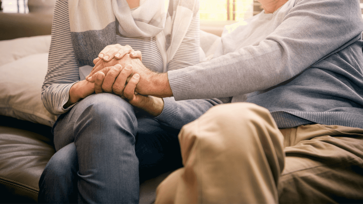 Two elderly people holding hands.