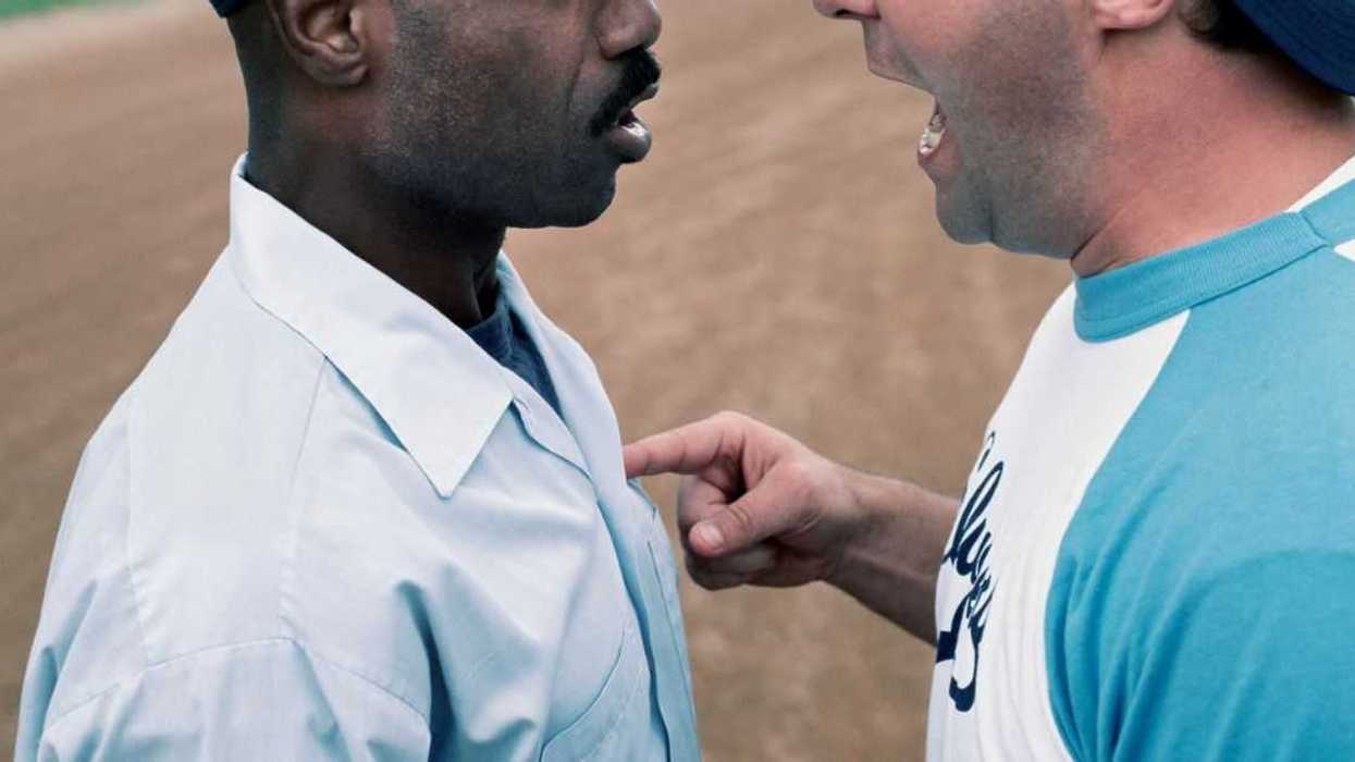Two men argue, one man pokes the other with his finger